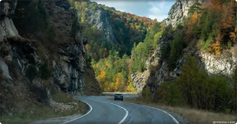 A car driving through the winding curves of a Carpathian road trip in the Făgăraș Mountains of Romania.