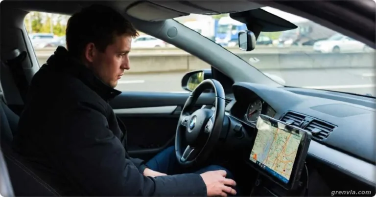 Driver parked in a parking lot next to a busy highway in Germany checking a route map on the car's navigation system