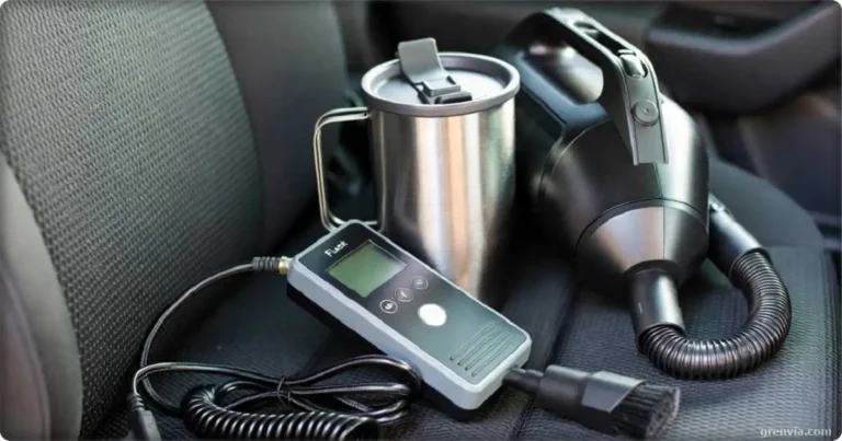 A collection of small travel gadgets on a car seat: a handheld tire inflator, a stainless steel travel mug, and a compact car vacuum.