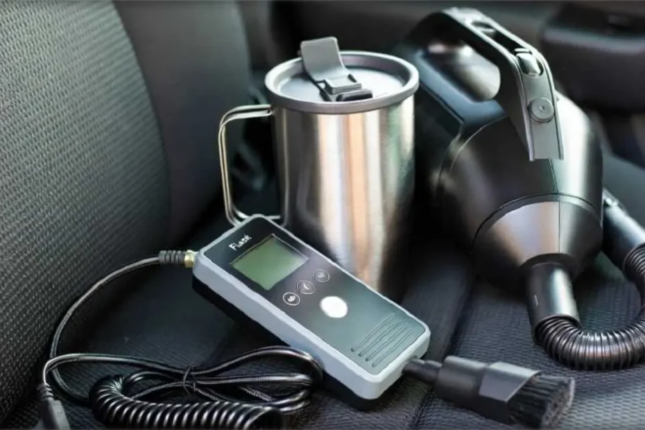 Small Gadgets That Make a Big Difference on Long Drives 10 A collection of small travel gadgets on a car seat: a handheld tire inflator, a stainless steel travel mug, and a compact car vacuum.